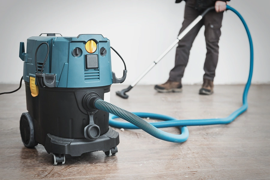 Industrial vacuum cleaner with person using hose.