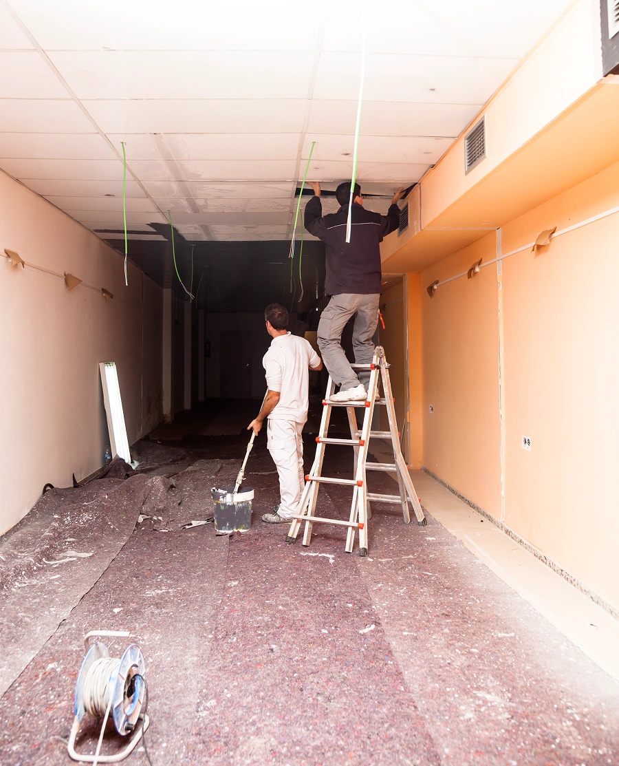 Construction workers on ladder in corridor