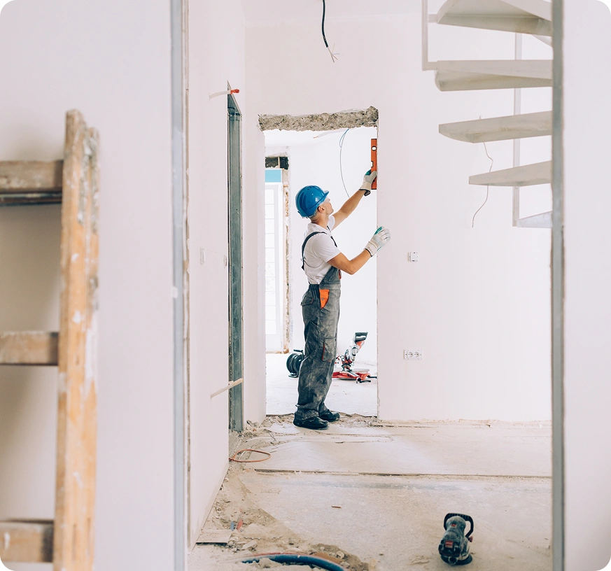 Construction worker measuring doorway